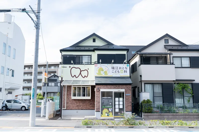 れんが調の1階に恐竜の絵の看板を掲げた医院の建物正面